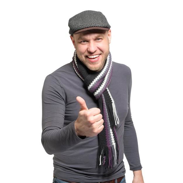 Un uomo sorridente con un cappello grigio e una sciarpa grigia con il pollice alzato verso l'alto Isolato