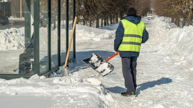 Un uomo spala la neve da un edificio.