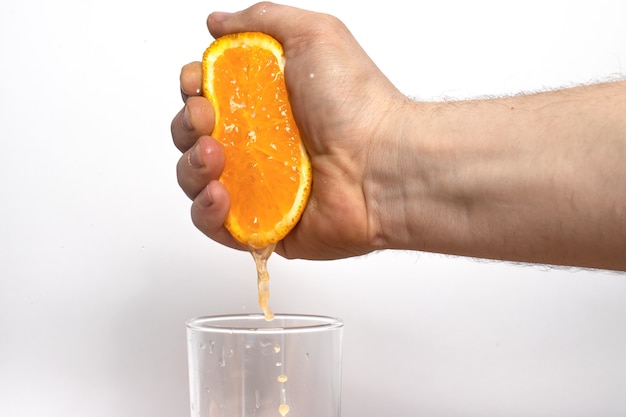 Un uomo spreme il succo da una succosa arancia matura.