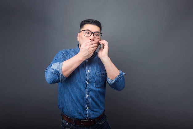 Un uomo sta facendo una telefonata con un&#39;espressione sorpresa.