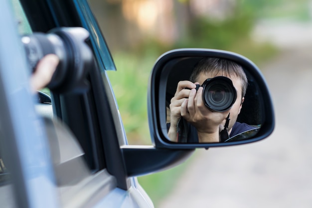 Un uomo sta fotografando qualcuno o qualcosa dal finestrino di un'auto aperto