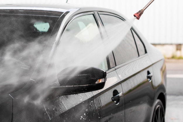 Un uomo sta lavando una macchina in autolavaggio self service. Idropulitrice per veicoli ad alta pressione pulita con acqua. Attrezzature per autolavaggio, Mlada Boleslav,