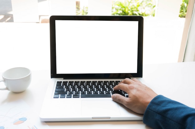 Un uomo sta lavorando usando un computer portatile sul tavolo di legno. Mani che digitano su una tastiera