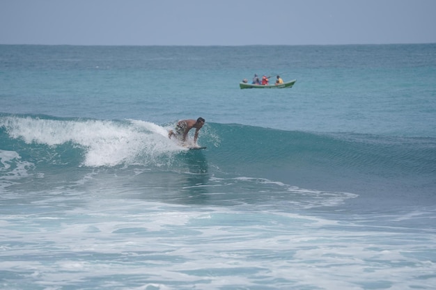 un uomo sta surfando l'onda sulla spiaggia