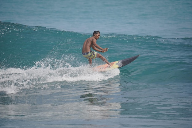 un uomo sta surfando l'onda sulla spiaggia