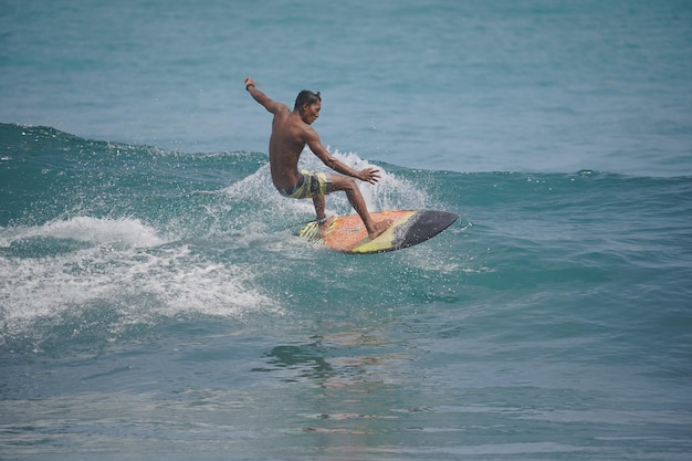 un uomo sta surfando l'onda sulla spiaggia