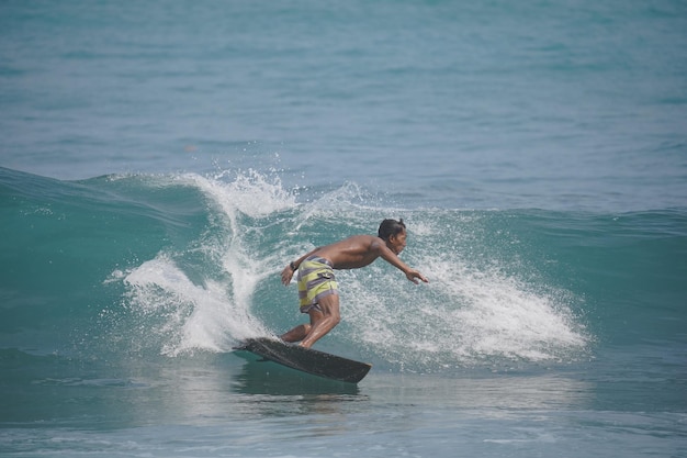 un uomo sta surfando l'onda sulla spiaggia