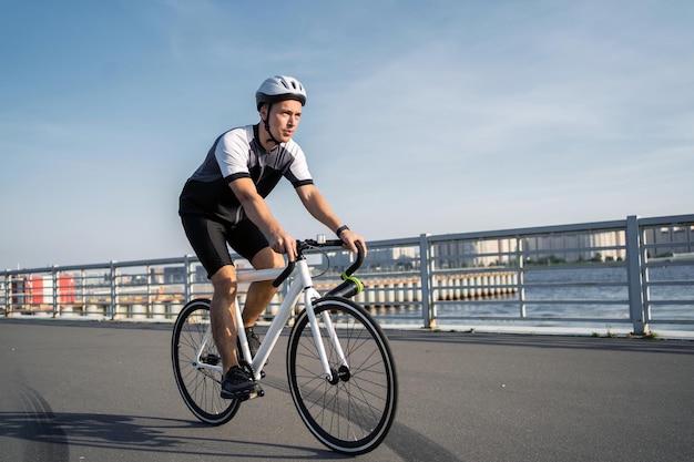 Un uomo su una bici da strada che indossa un casco cavalca in abiti da ciclismo Trasporto ecologico in città