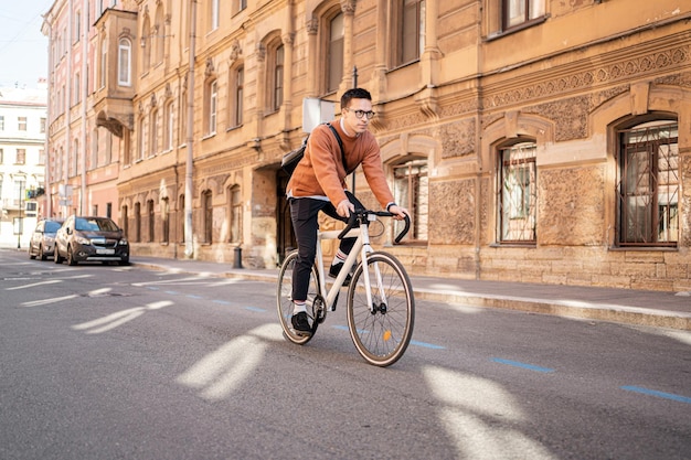 Un uomo su una bicicletta da lavoro va a lavorare con il trasporto ecologico urbano