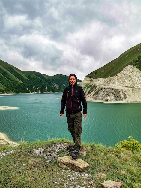 Un uomo sullo sfondo del lago Kezenoyam nelle montagne del Caucaso in Cecenia Russia giugno 2021