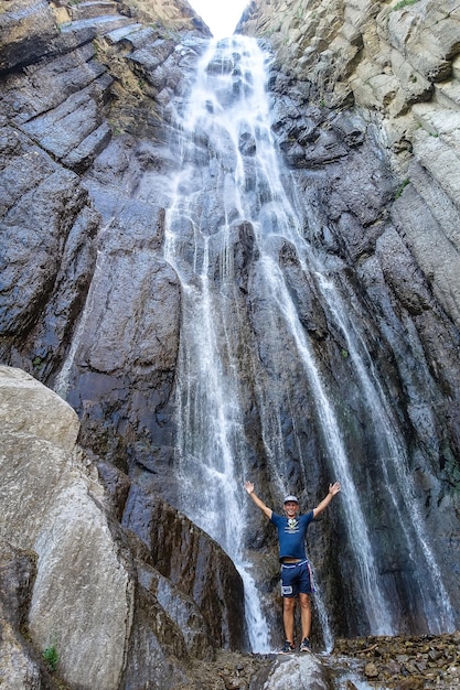 Un uomo sullo sfondo della cascata AbaiSu Caucaso settentrionale KabardinoBalkaria giugno 2021