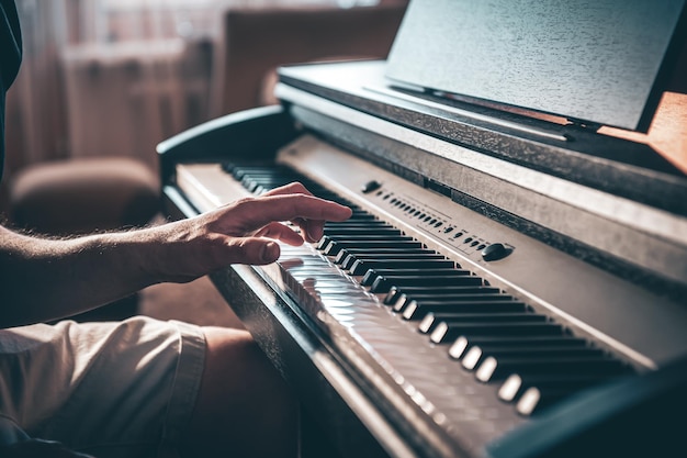 Un uomo suona un pianoforte elettronico in una stanza buia