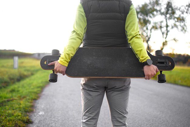 Un uomo tiene il suo longboard e si prepara a cavalcare