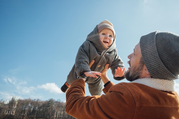 Un uomo tiene in aria un bambino.