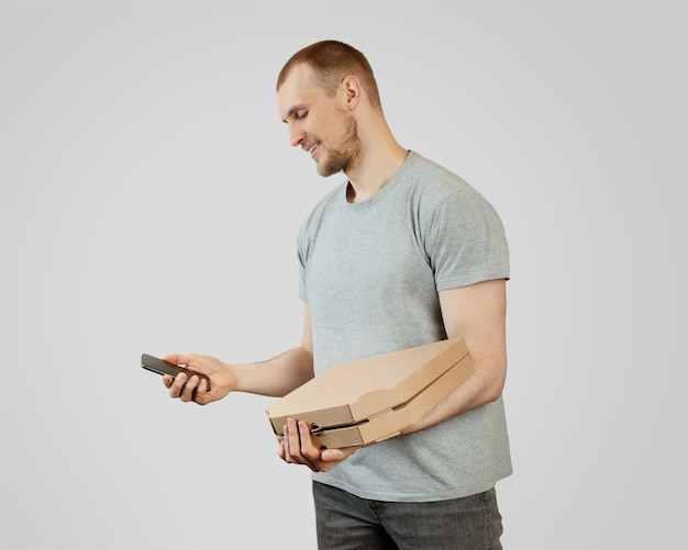 Un uomo tiene in mano un telefono e una pizza su sfondo neroConsegna pizza
