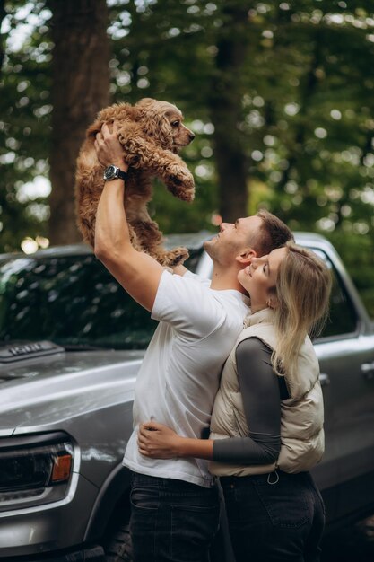 un uomo tiene un cane cocker spaniel tra le braccia alzate e una ragazza lo abbraccia