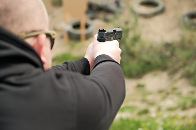 Un uomo tiene una pistola nelle sue mani esercizi di tiro con la pistola