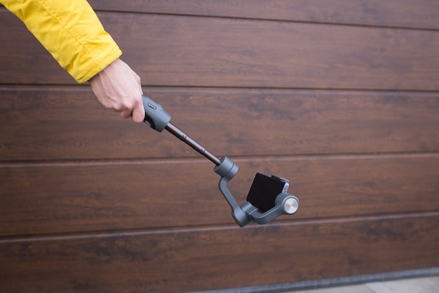 Un uomo tiene uno stabilizzatore per smartphone.