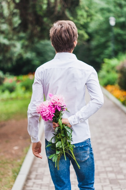 Un uomo va ad oggi e porta un bellissimo mazzo di fiori