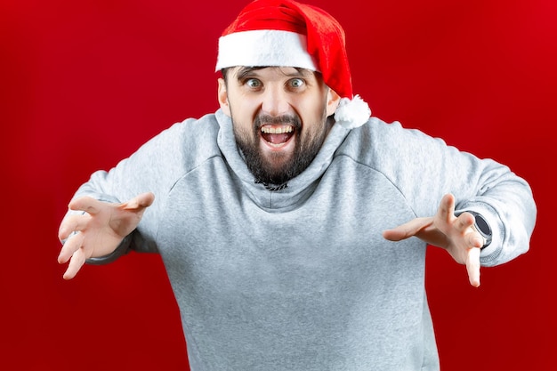 Un uomo vestito con abiti natalizi tiene in mano un selfie stick con un telefono attaccato e sta facendo un selfie