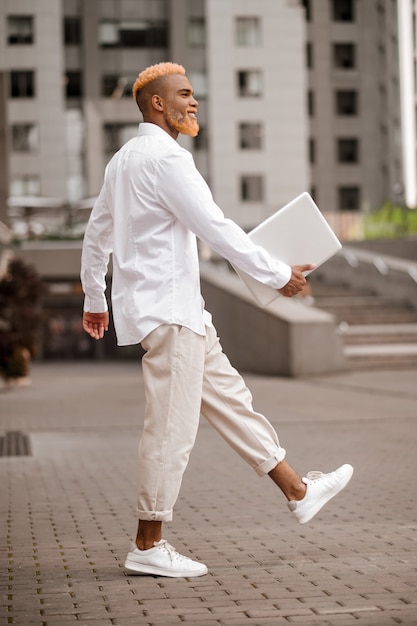 Un uomo vestito di bianco con un gadget in mano