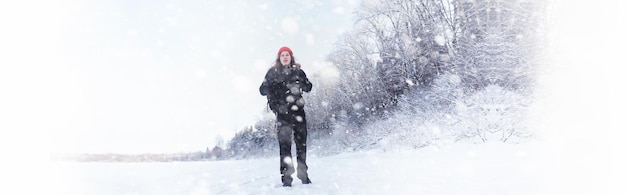 Un uomo viaggia con uno zaino. Escursione invernale nella foresta. Turista in una passeggiata in inverno nel parco.