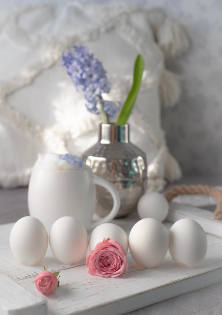 Un uovo bianco con un fiore rosa nel mezzo e un mucchio di uova nel mezzo.