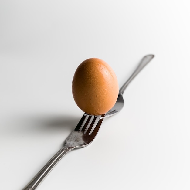 Un uovo che è posto sulla cima di due forchette