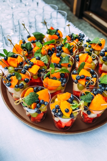 Un vassoio con bicchieri con fettine di frutta colorate per le vacanze.