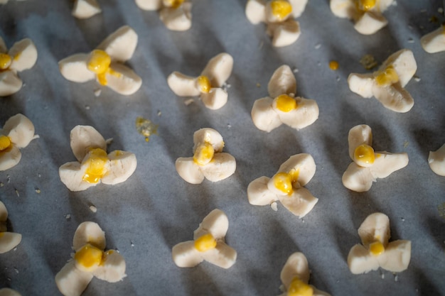 Un vassoio di amaretti al cioccolato bianco con fiori gialli in cima.