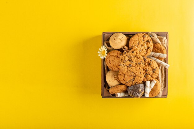 Un vassoio di legno di biscotti su giallo