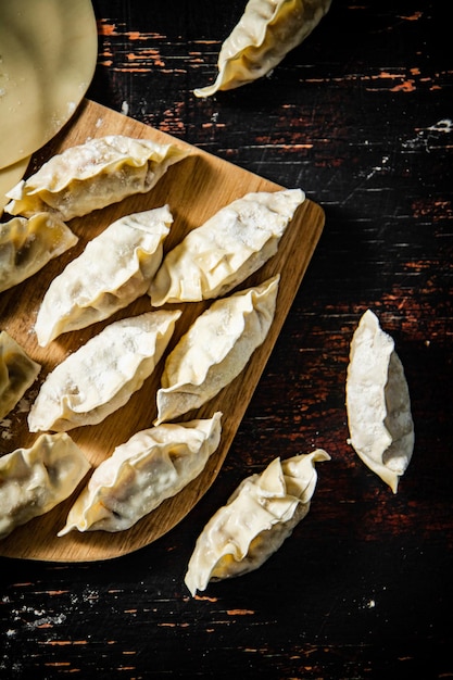 Un vassoio di legno di gnocchi con sopra un formaggio