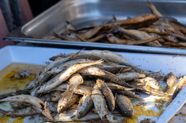 Un vassoio di sardine è riempito con un mucchio di sardine.