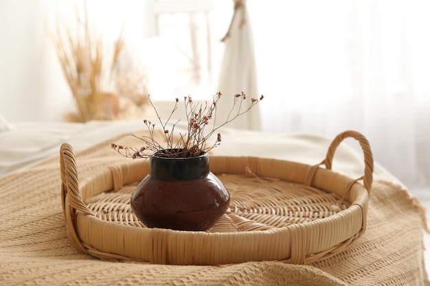 Un vassoio di vimini sul letto la mattina presto un vaso sul vassoio tutto nei toni del beige