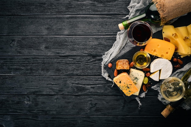 Un vasto assortimento di formaggi formaggio brie gorgonzola formaggio blu uva miele noci vino rosso e bianco su un tavolo di legno Vista dall'alto Spazio libero per il testo
