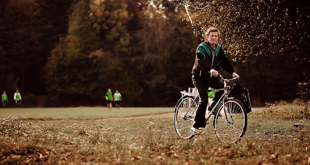 Un vecchio che corre in bicicletta