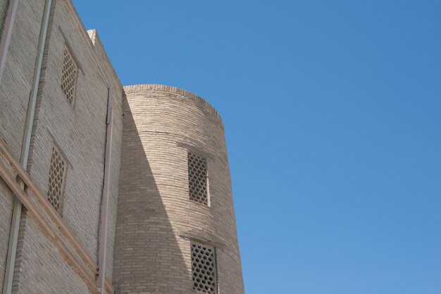 Un vecchio edificio in mattoni con una torre. Antichi edifici dell'Asia medievale. Bukhara, Uzbekistan