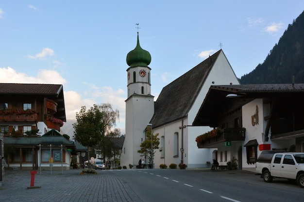Un vecchio municipio con una chiesa in una piccola città tedesca vicino a una montagna