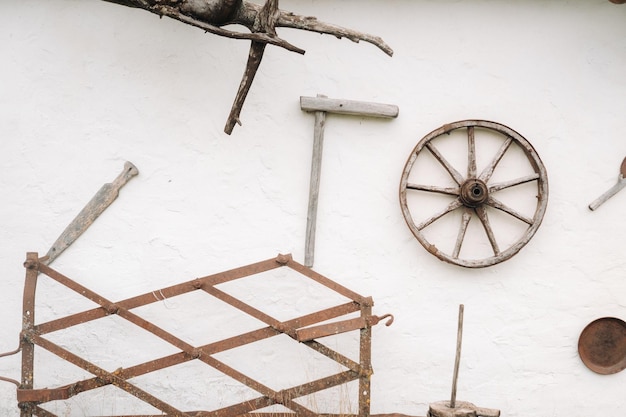 Un vecchio muro di legno di una casa nel villaggio e antichi attrezzi per ruote di carrelli ecc