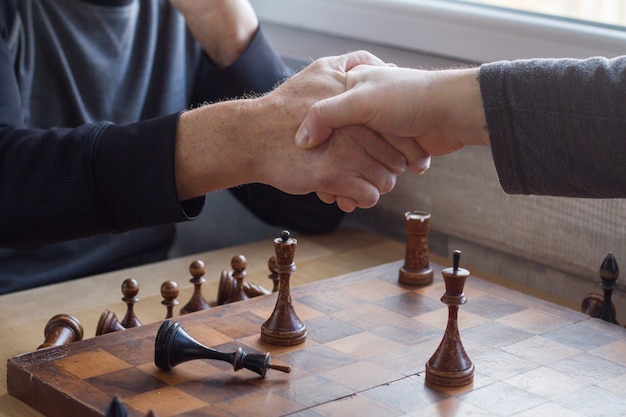 Un vecchio stringe la mano a un avversario in una partita a scacchi