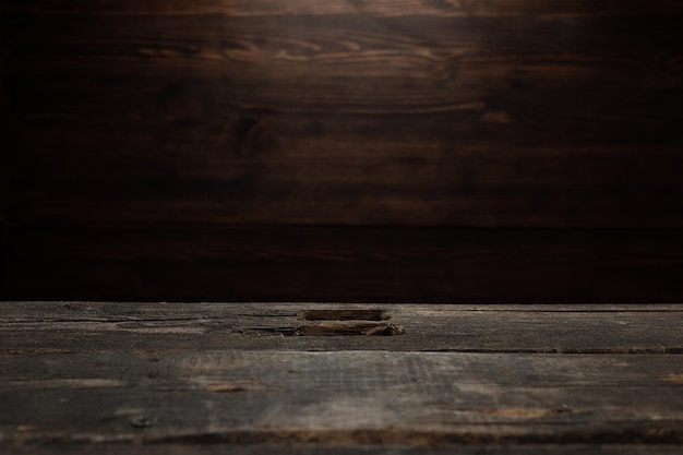 Un vecchio tavolo di legno squallido e malconcio e una parete in legno scuro che cucina lo sfondo