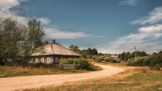 Un vecchio villaggio con case di legno e una strada sterrata nel nord della Russia in estate