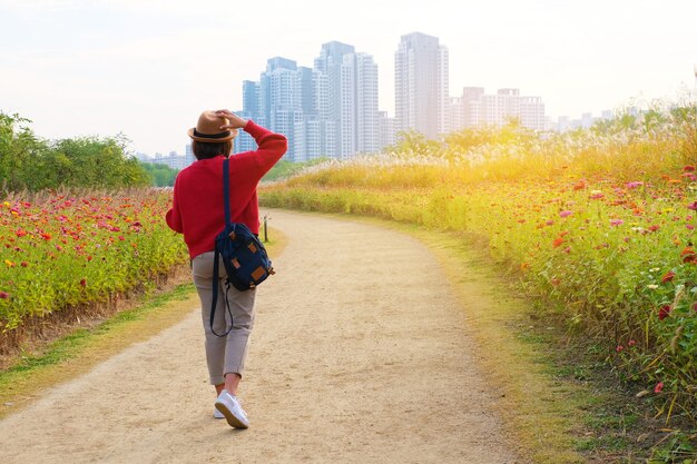 Un viaggiatore che cammina nel parco dei fiori fino all'edificio a Seoul Korea