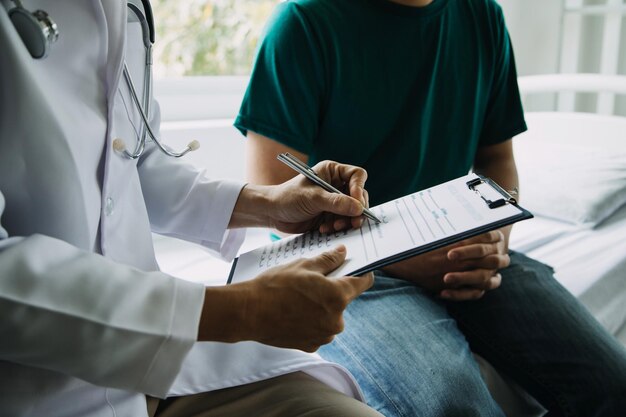 Un visitatore sanitario con tablet che spiega a una donna anziana come prendere le pillole