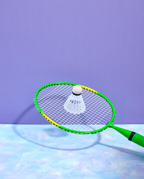 Un volano da badminton bianco su una racchetta da badminton verde Il processo di una squadra di gioco sportivo