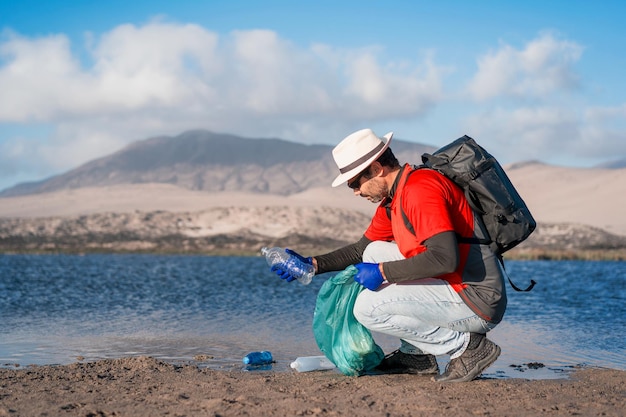 Un volontario raccoglie i rifiuti di plastica sulla spiaggiax9