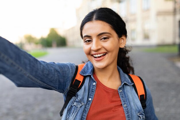 Una allegra studentessa indiana che si fa un selfie nel campus universitario