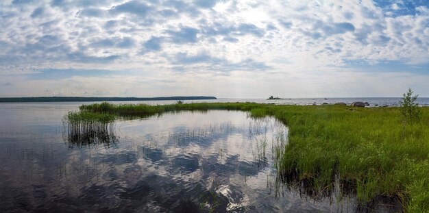 Una baia con un riflesso del cielo con le nuvole sul Lago Ladoga