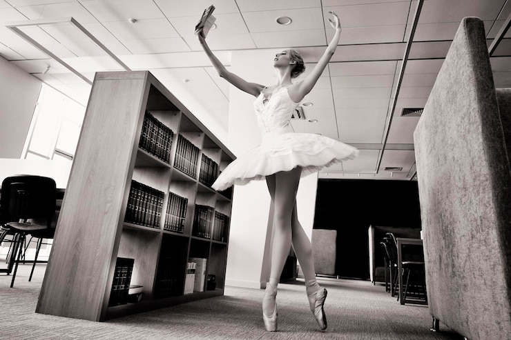 Foto una ballerina affascinante è andata in biblioteca per scegliere un nuovo libro durante una pausa