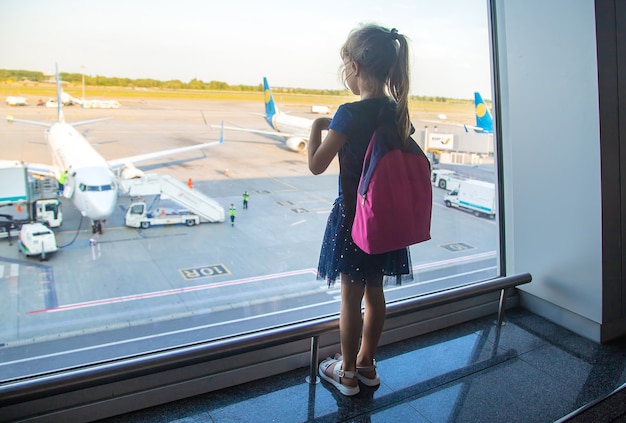 Una bambina all'aeroporto guarda gli aerei